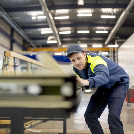 Monter wyrównujący profile okienne w odzieży ochronnej.