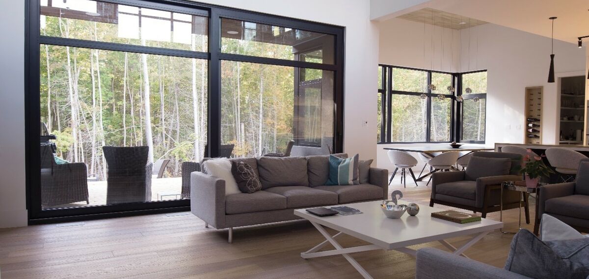 Wygłuszanie mieszkania: widok na nowoczesny salon z oknami aluminiowymi