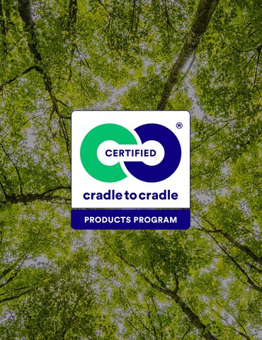 Logo Cradle to Cradle na tle zielonych czubków drzew.