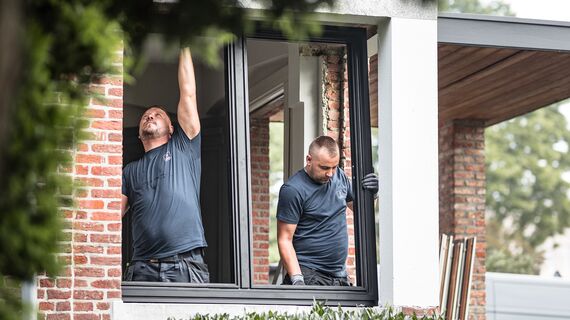 Dwóch instalatorów umieszcza nowy profil aluminiowy w odnowionym domu.